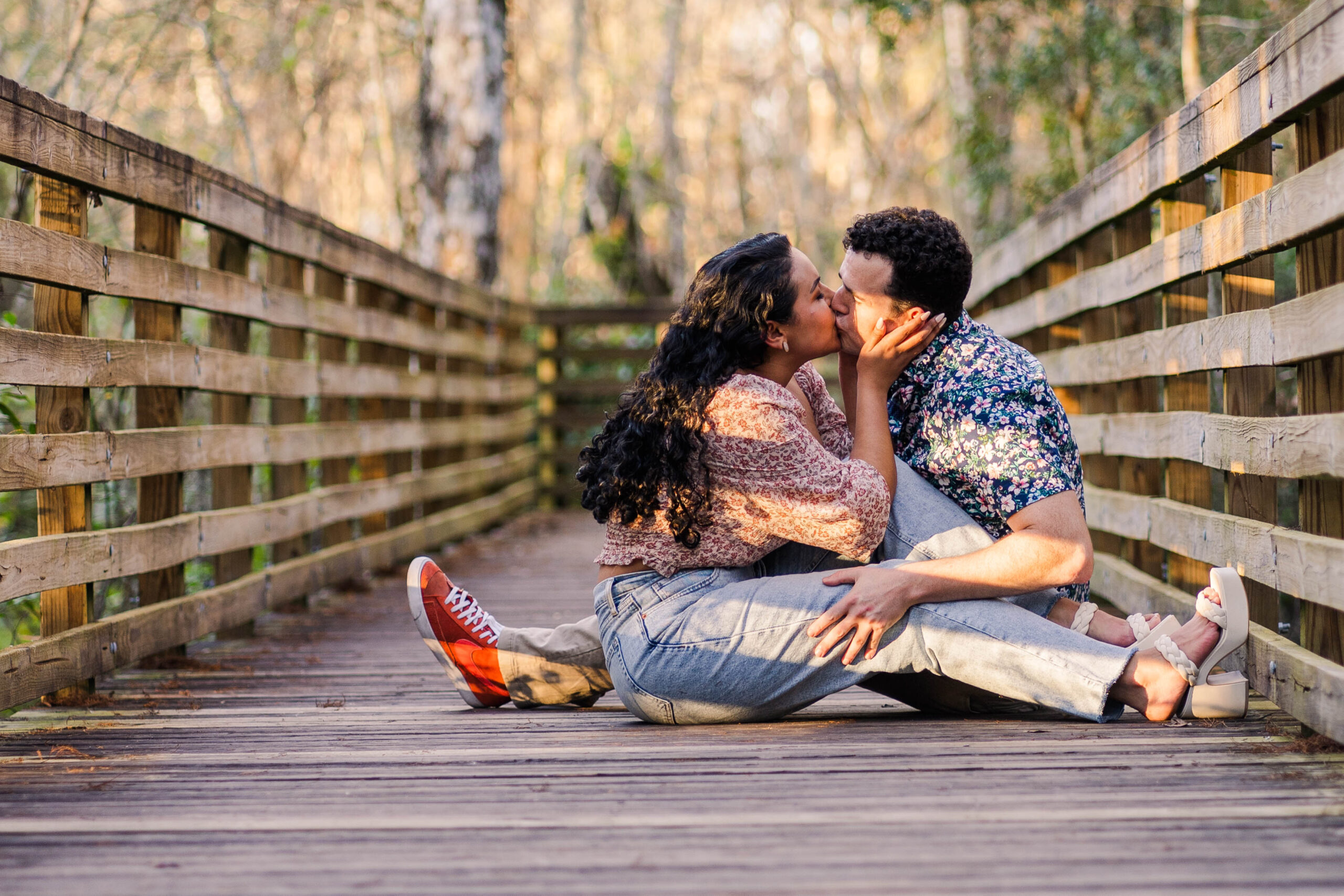 Engaged couple sit and kiss at Eureka Springs Park in Tampa, Florida.