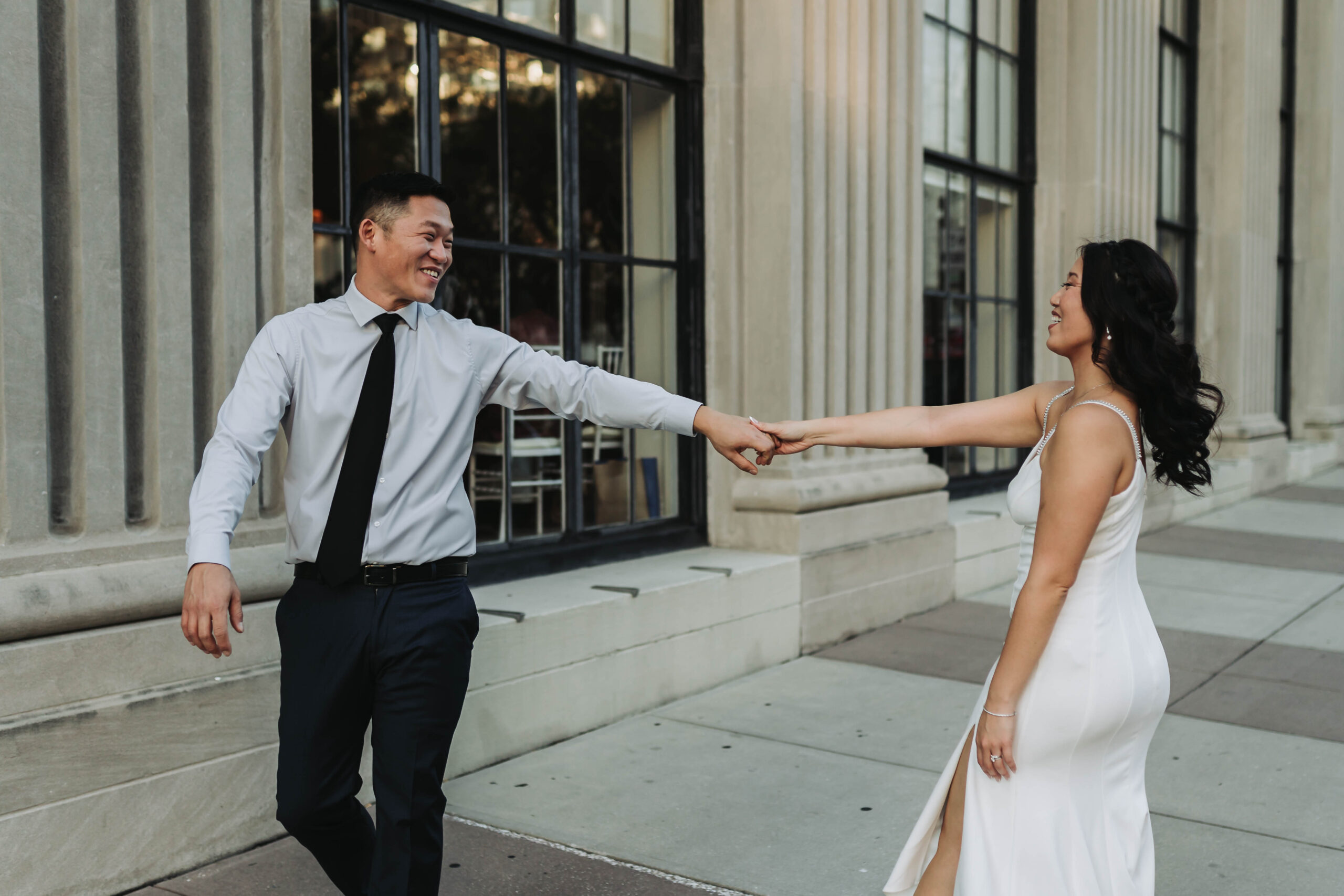 Couple in wedding attire dancing in Downtown Tampa for their engagement photos